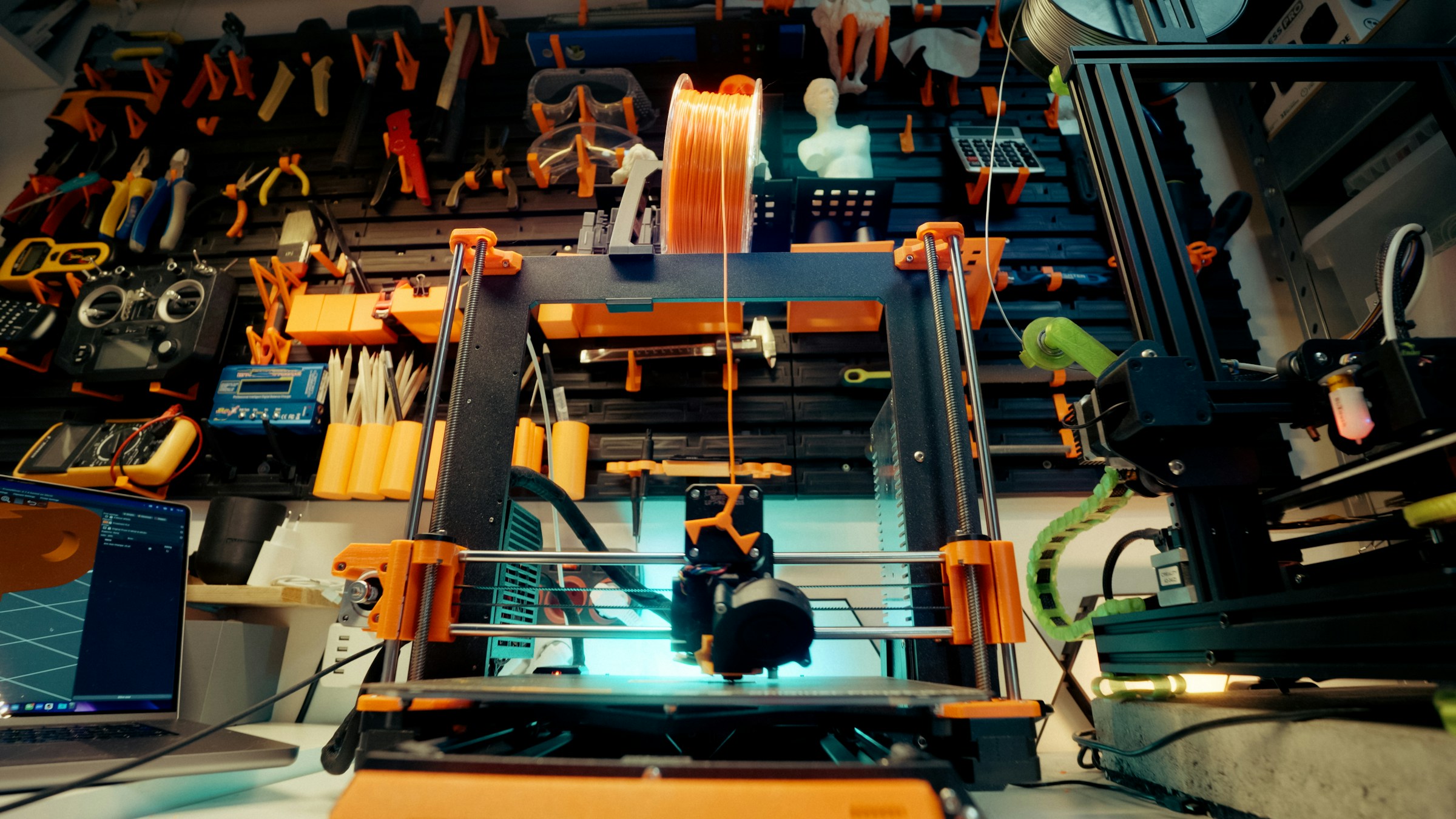 A 3D printer working in a tool-filled workshop, illustrating a possible prototyping workflow